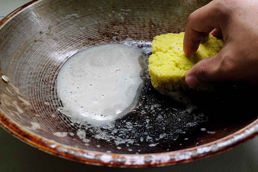 person scraping grease off dishes and pans York, SC