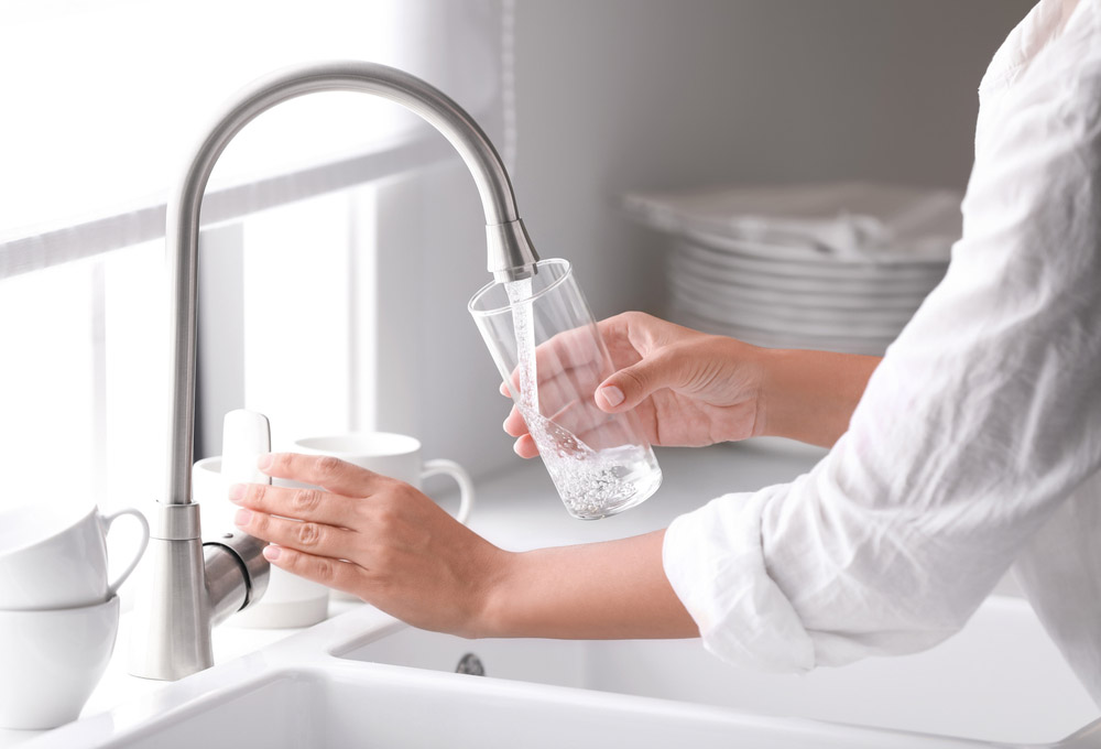 drinking glass being filled with tap water