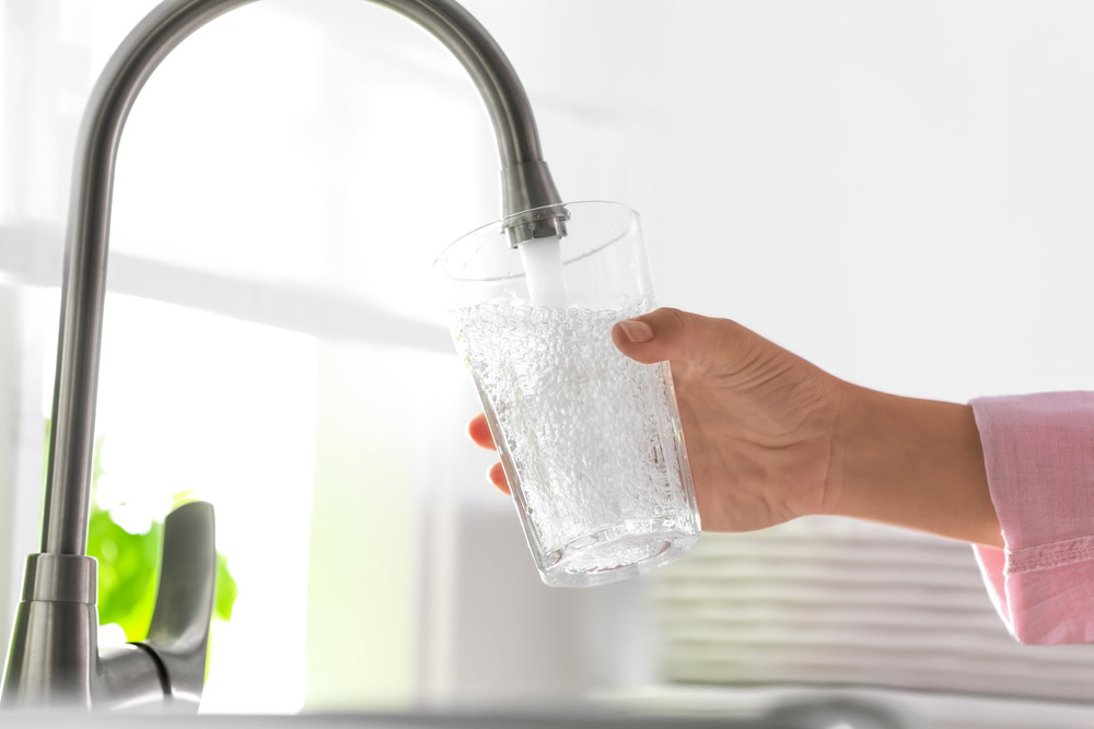 person getting tap water