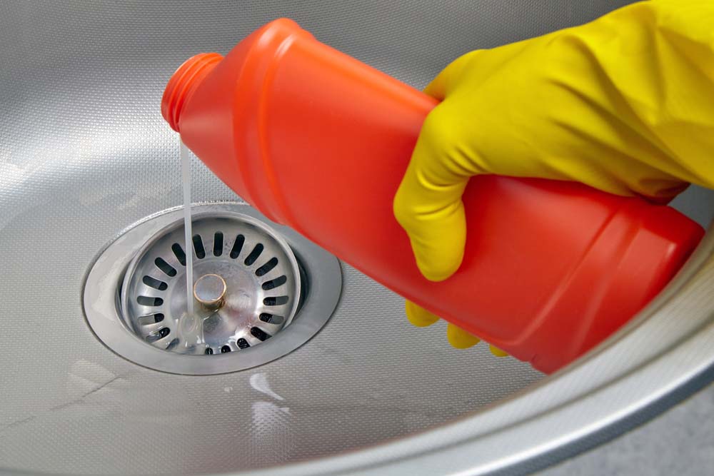 person holding a drain cleaning solution